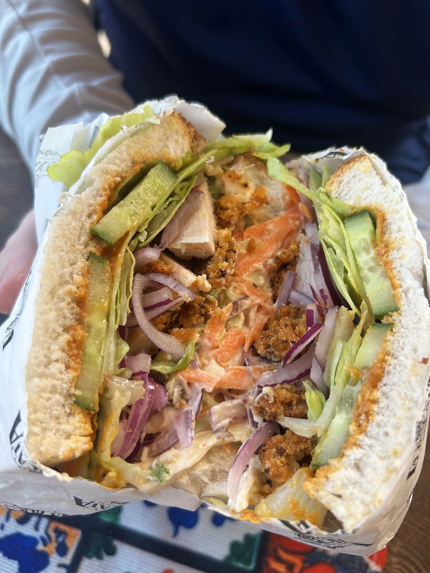A stacked bocata filled with falafel, tomato, red onion and salad