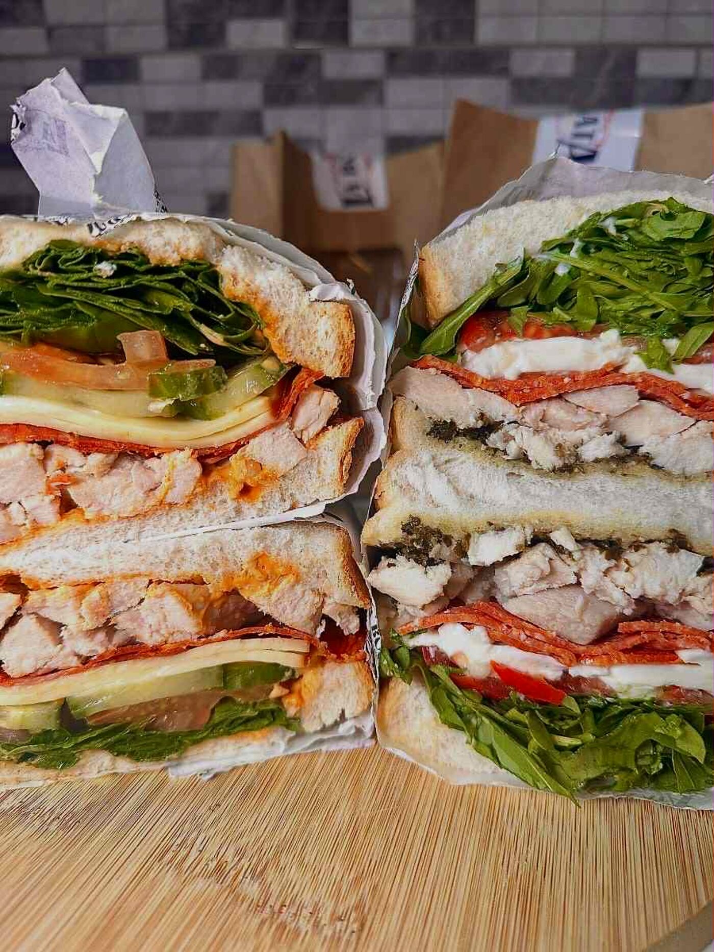 Two halves of a bocata in La Bocata's printed greaseproof wrap, cross-sections facing out